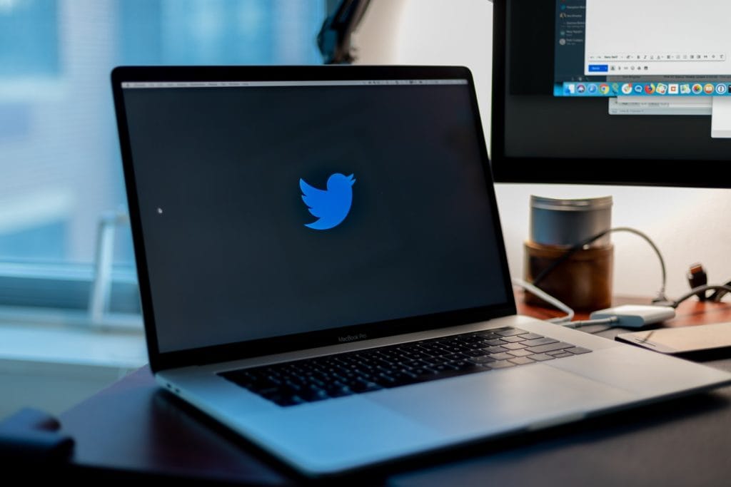 Laptop encendida con el logo de Twitter en pantalla